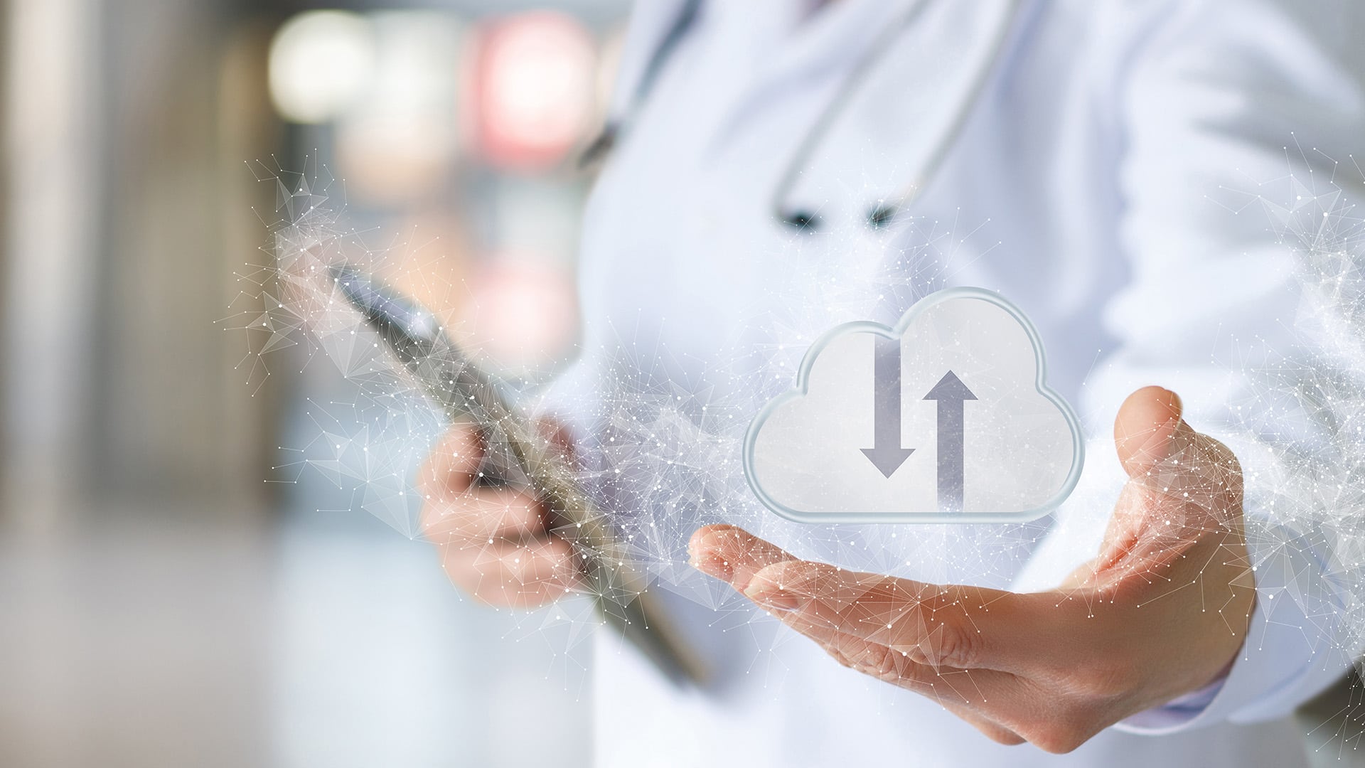 healthcare worker holding a tablet in one hand and a graphic of a small cloud icon in the other